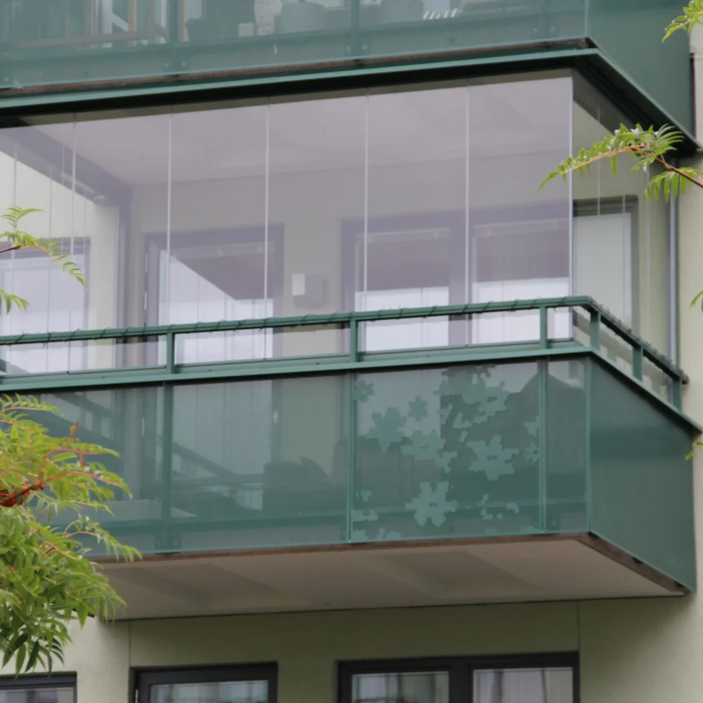 Inglasning av balkong med grönt räcke